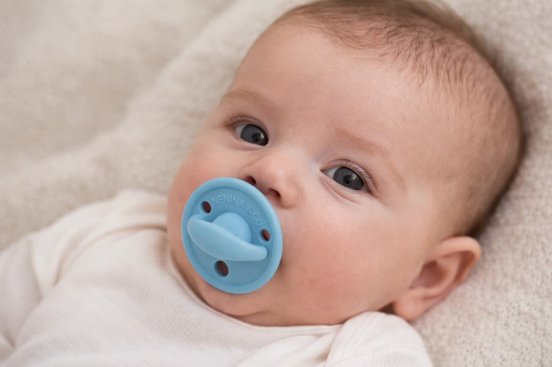 Bebé de tres meses usando un chupete azul de silicona orgánica de Nenina & Co.