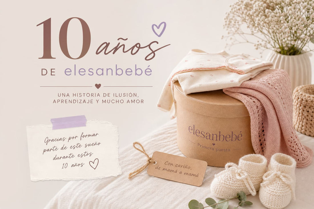 Escena cálida con ropa de bebé de primera puesta doblada sobre una caja con el logo de elesanbebé, patucos y mensaje manuscrito celebrando los 10 años.