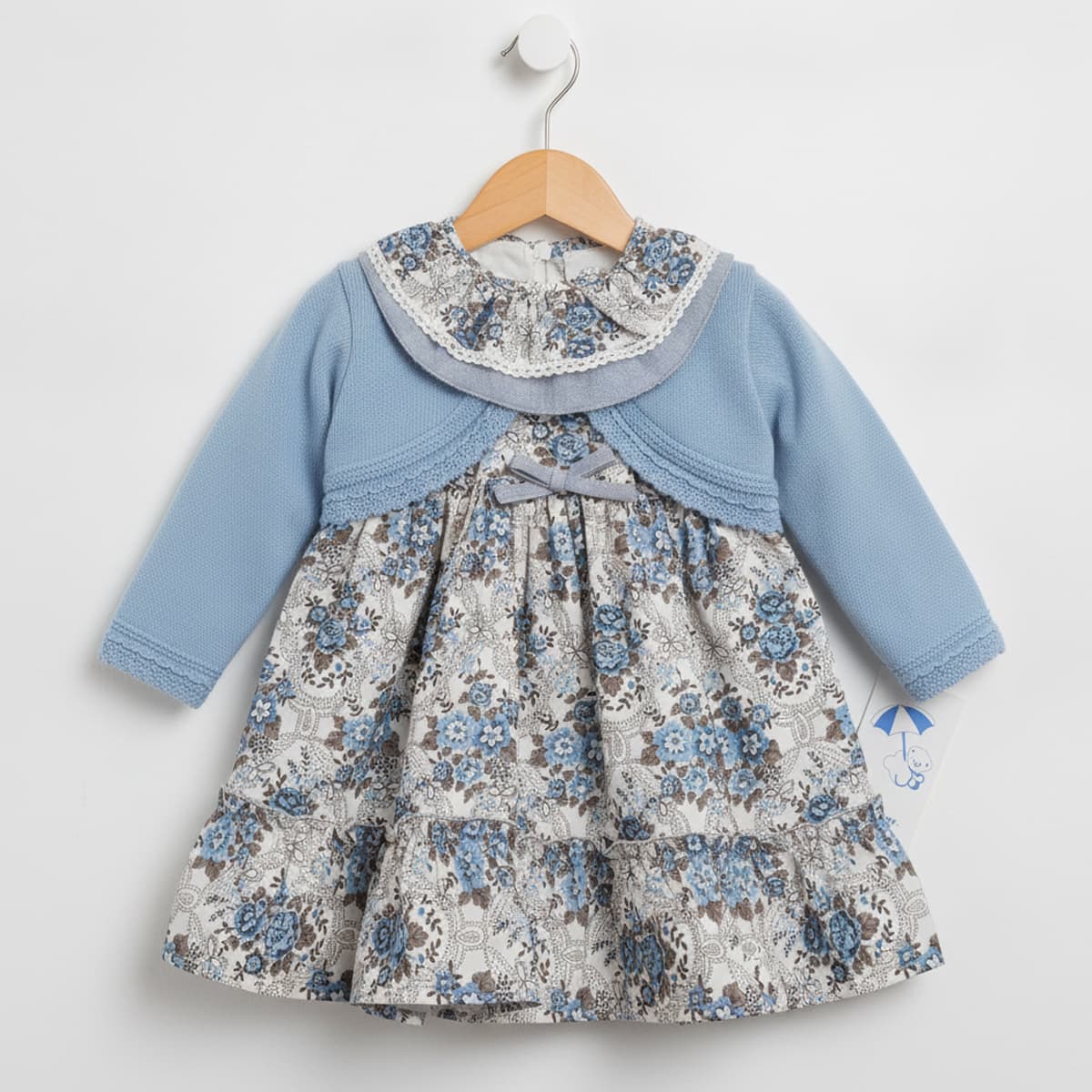 Conjunto de bebé niña de dos piezas con vestido floreado y chaqueta de punto celeste Modelo 26642 - Fabricado en España